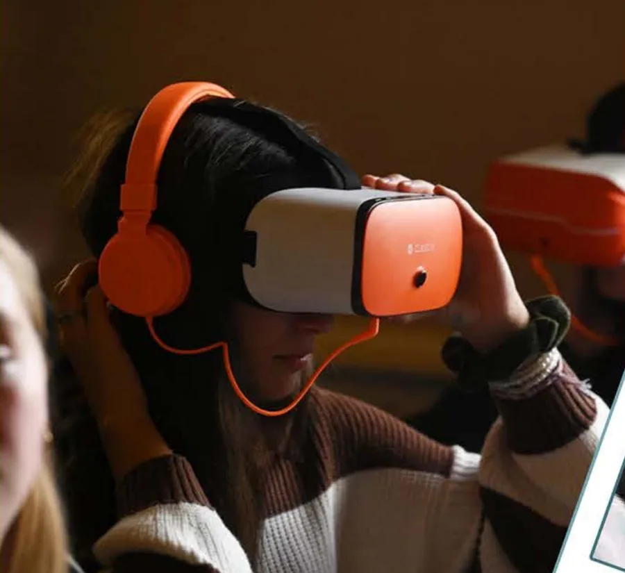 Alumna sonriendo mientras se coloca unas gafas de realidad virtual ClassVR