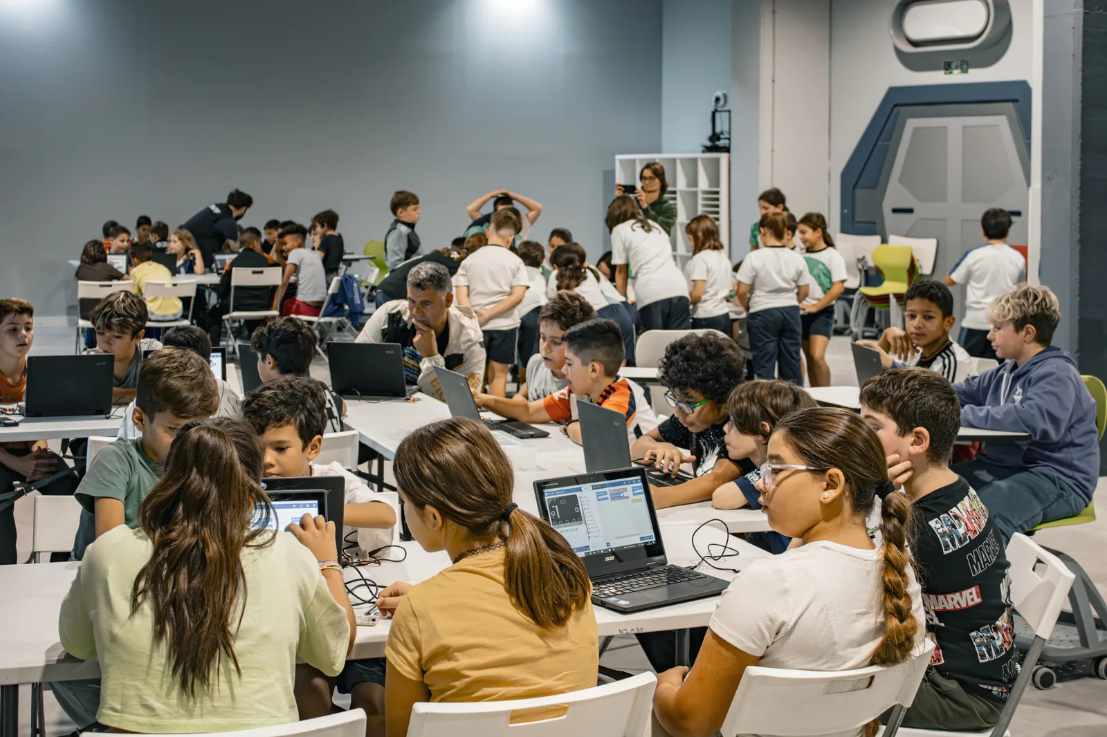 Sala de formación llena, con docentes trabajando con portátiles