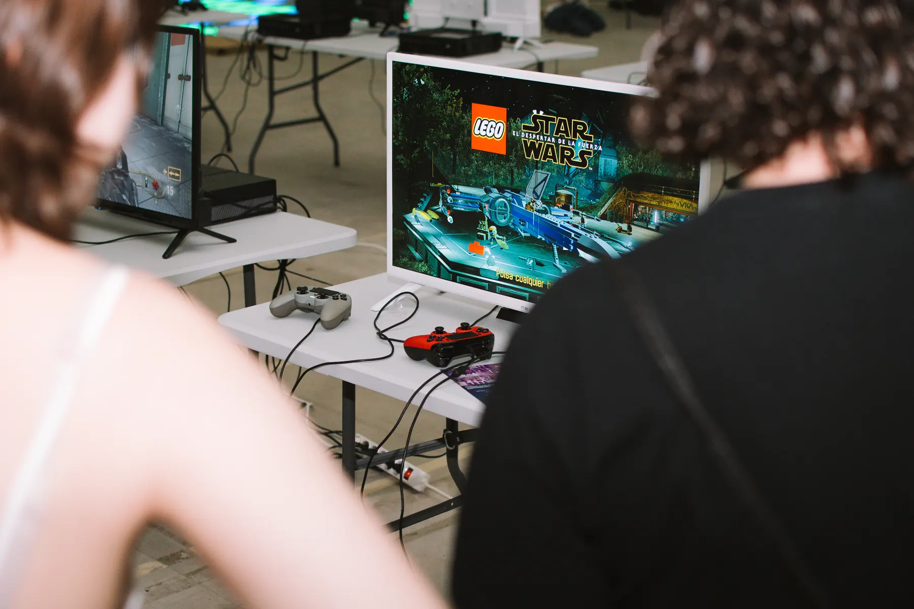 Zona gaming con pantallas y participantes jugando